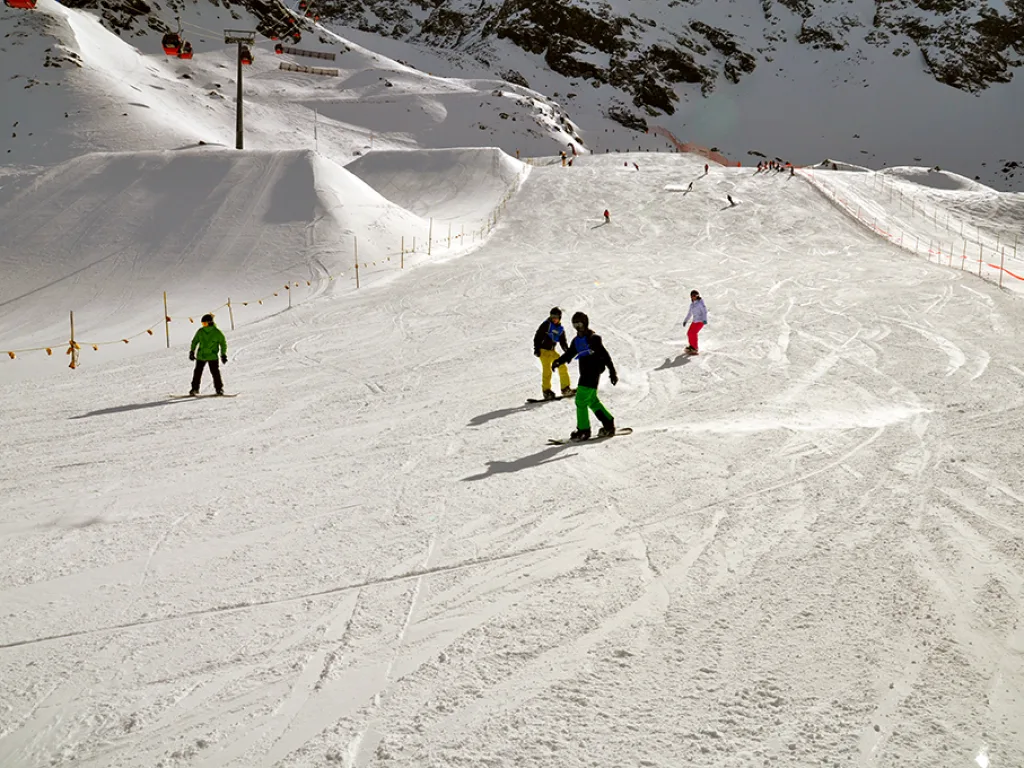 Skifahrende und Snowboardende verteilt am Hang.